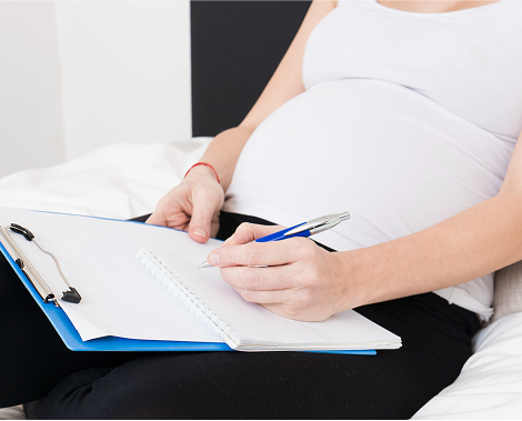 Pregnant woman focusing on writing