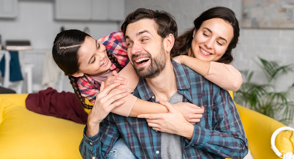 Mother, father, and daughter smiling while sitting