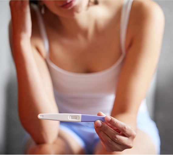 Woman anxious holding pregnancy test