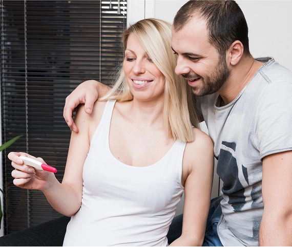 Woman and husband enjoying Pregnancy Test